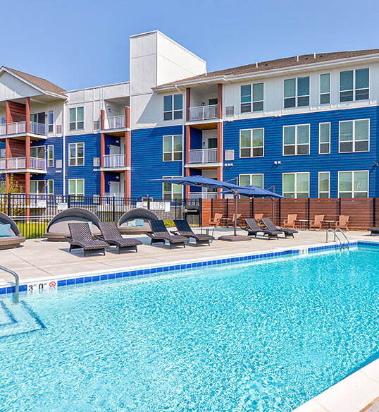 a food tray with a candle, a muffin and coffee on a dark couch