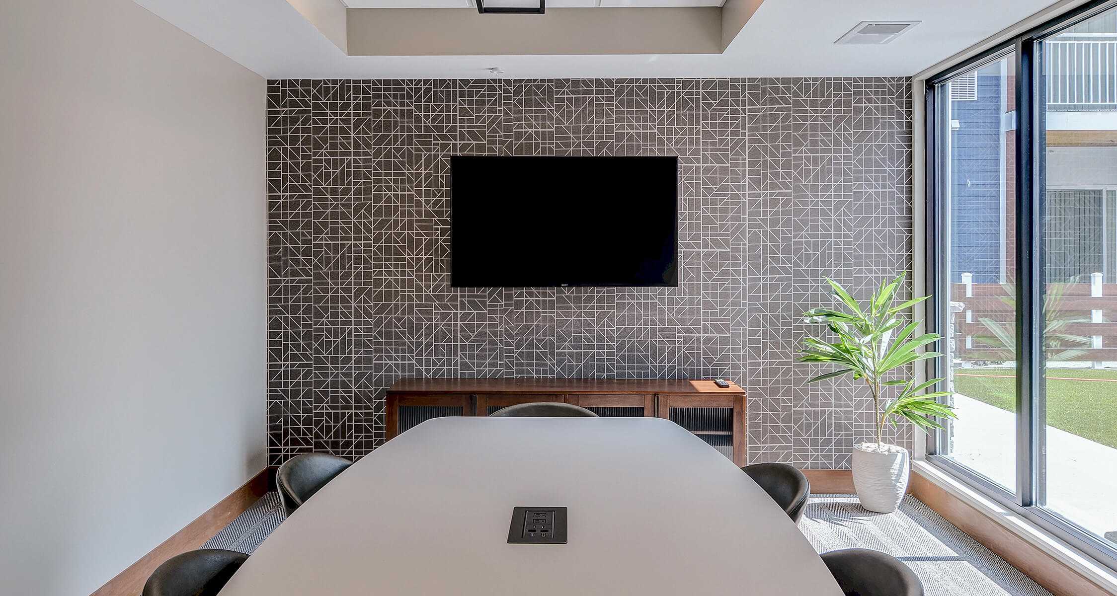 a young man sitting against a tree in the park with his bike in front of him.