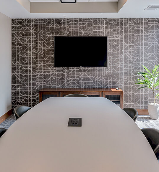 a young man sitting against a tree in the park with his bike in front of him.
